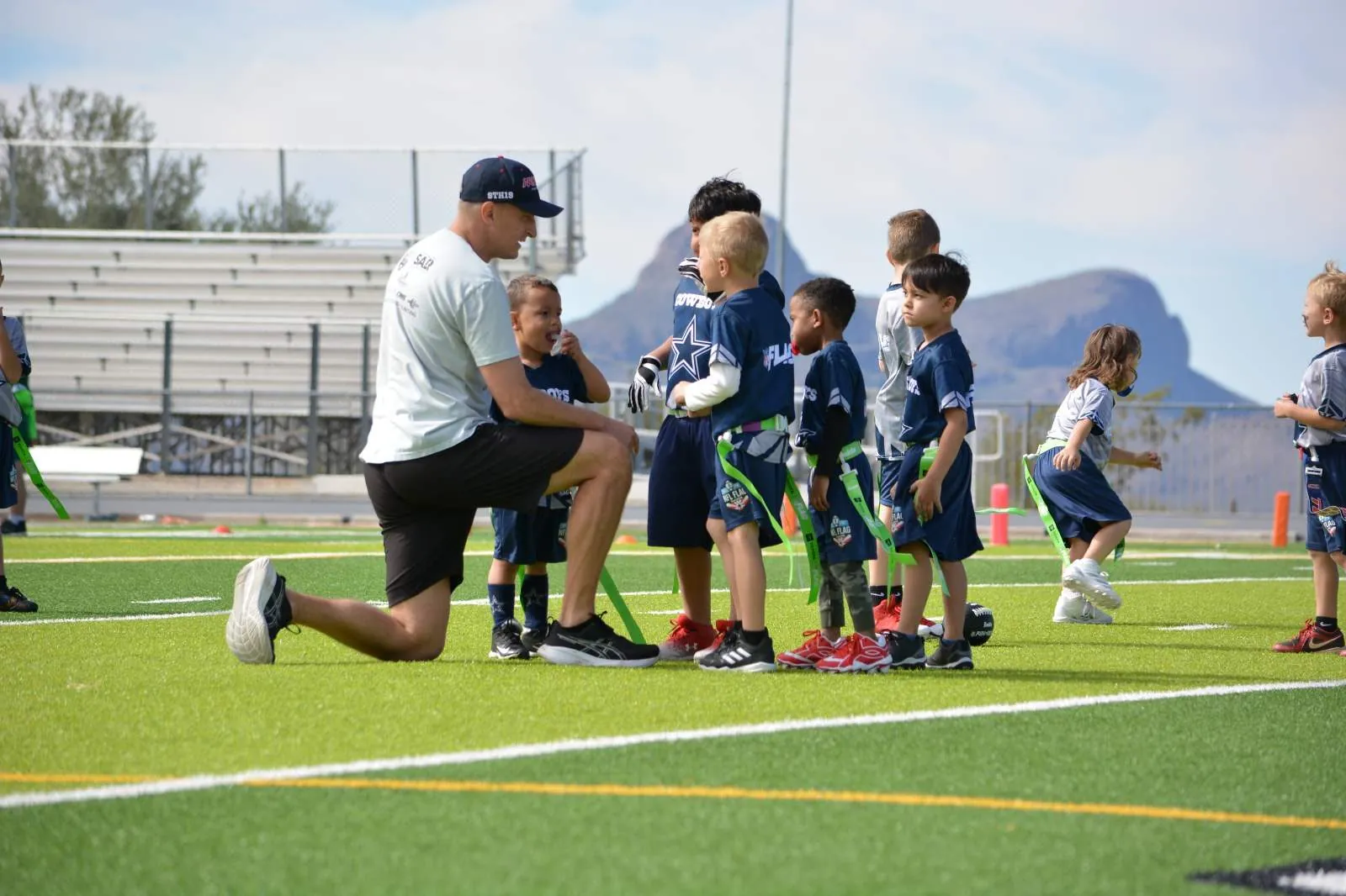 Coach working with young players at practice, Catalina mountains in the distance