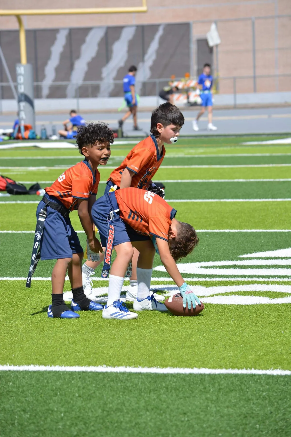 Young players lined up at the line of scrimmage waiting for the snap